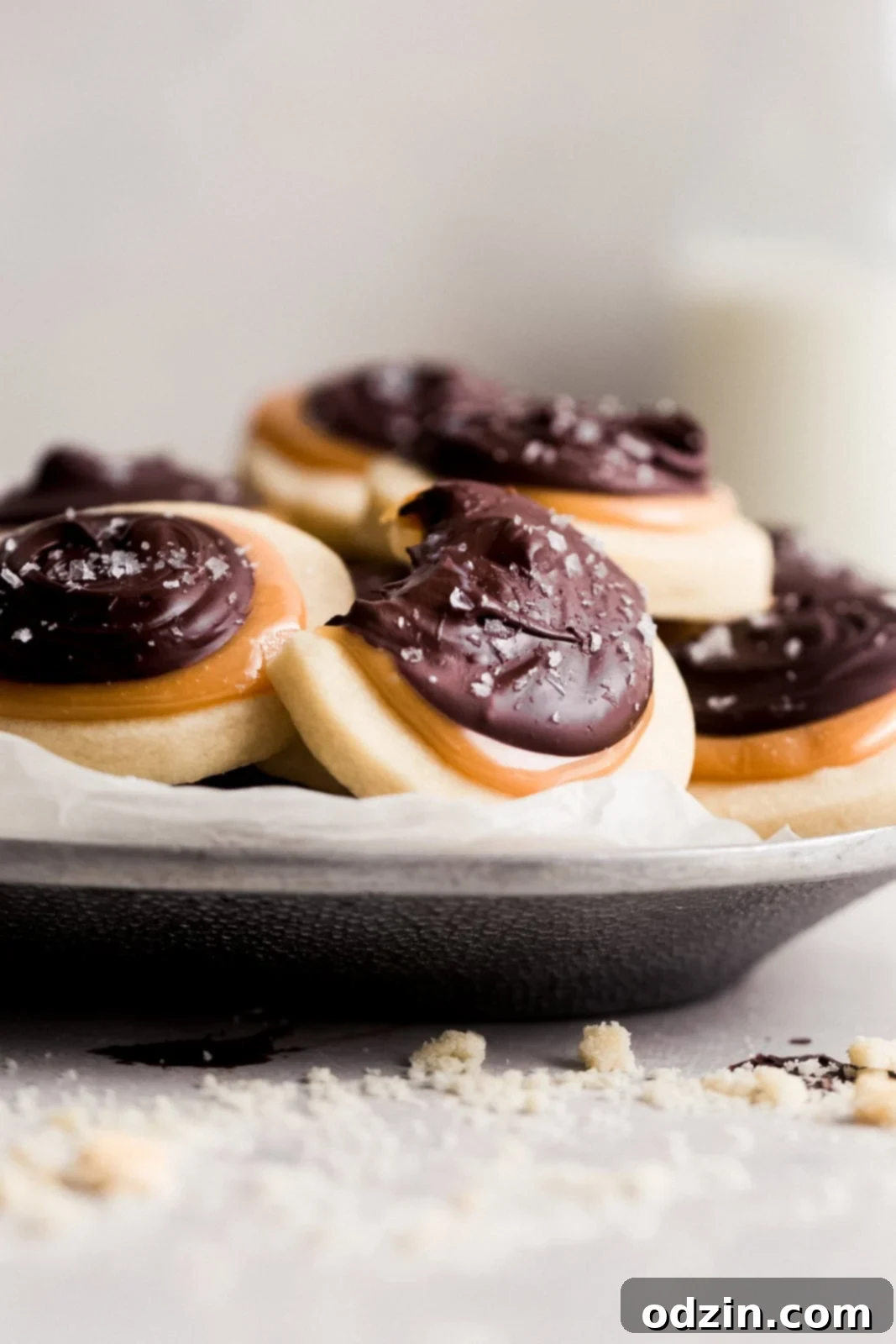 Copycat Twix Shortbread Cookies 7 metal plate lined with parchment to holding a trayful of cookies