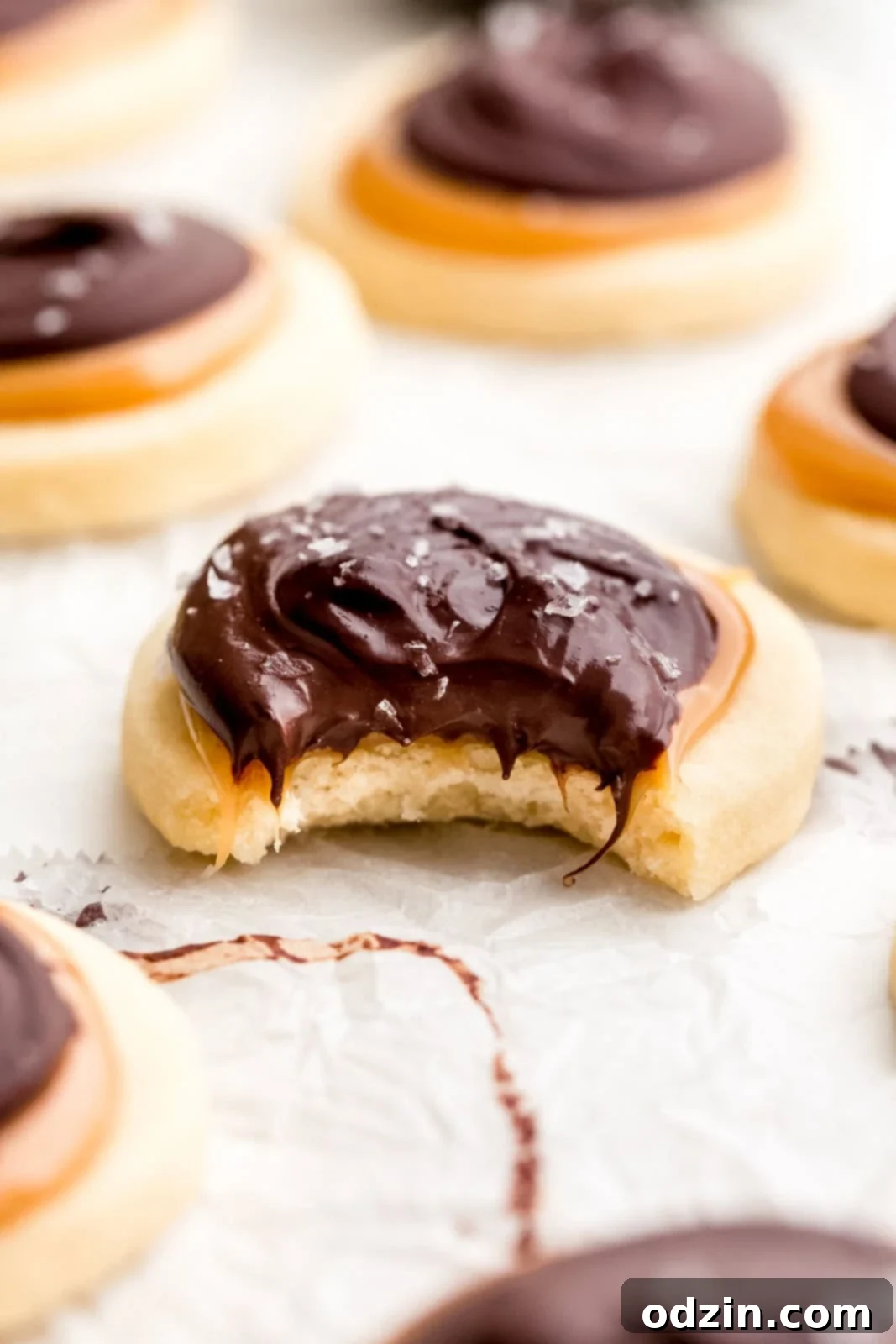 Copycat Twix Shortbread Cookies 8 close up of Twix cookie with a bite taken out of it to show caramel and chocolate