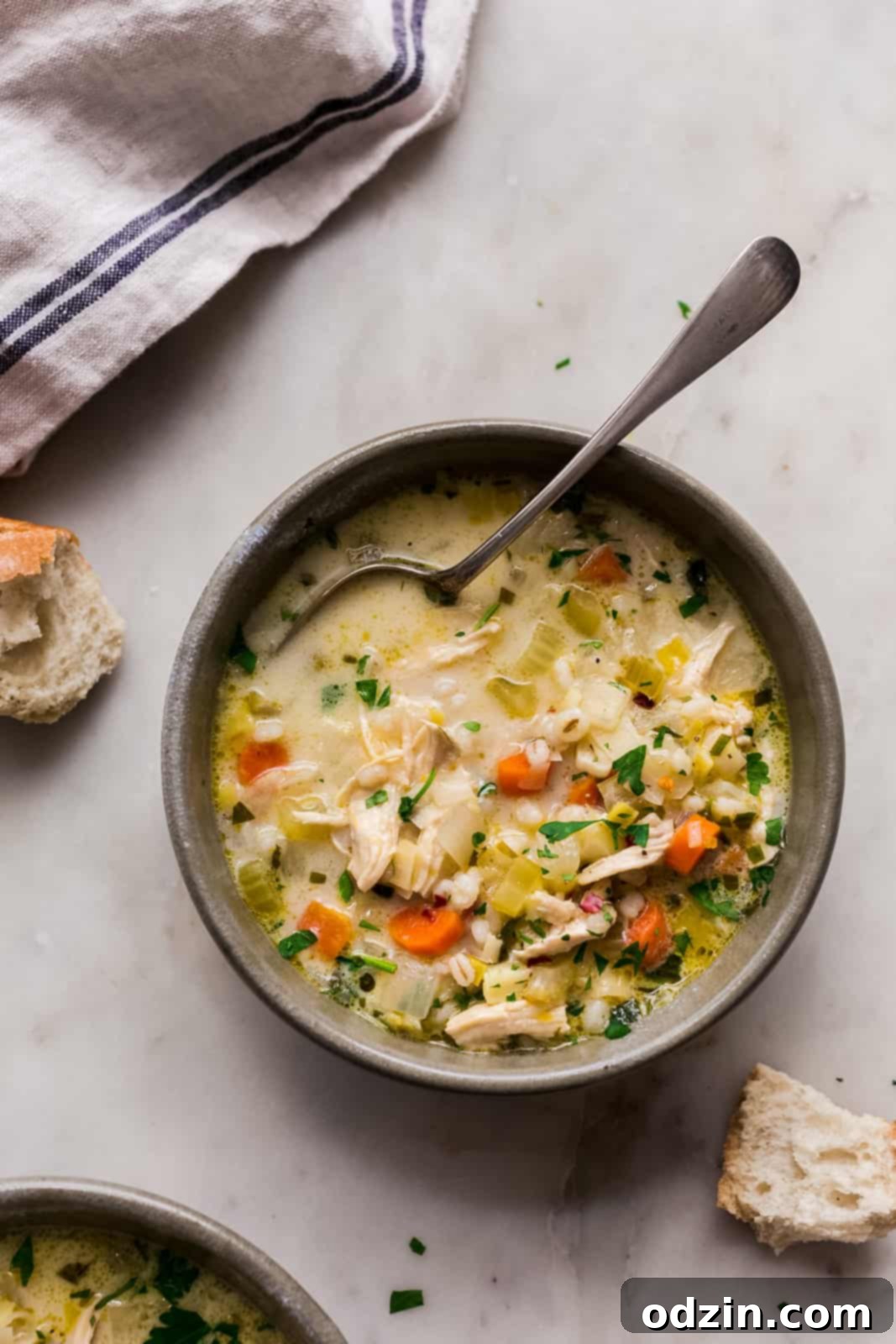 Sunshine Lemon Chicken Barley Soup 6 bowl of chicken barley soup on white marble surrounded by fresh broken bread