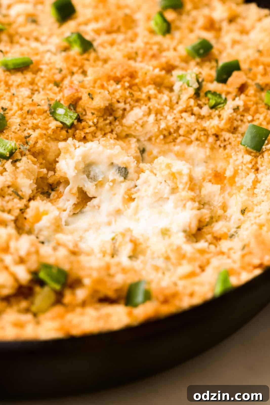 Close-up of creamy, cheesy jalapeño popper dip with visible jalapeño pieces