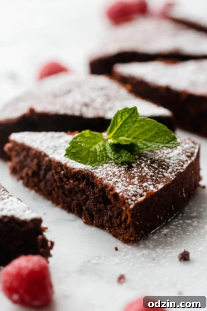 Caprese Flourless Chocolate Cake 2 slice of Caprese cake dusted with powdered sugar and topped with mint leaves