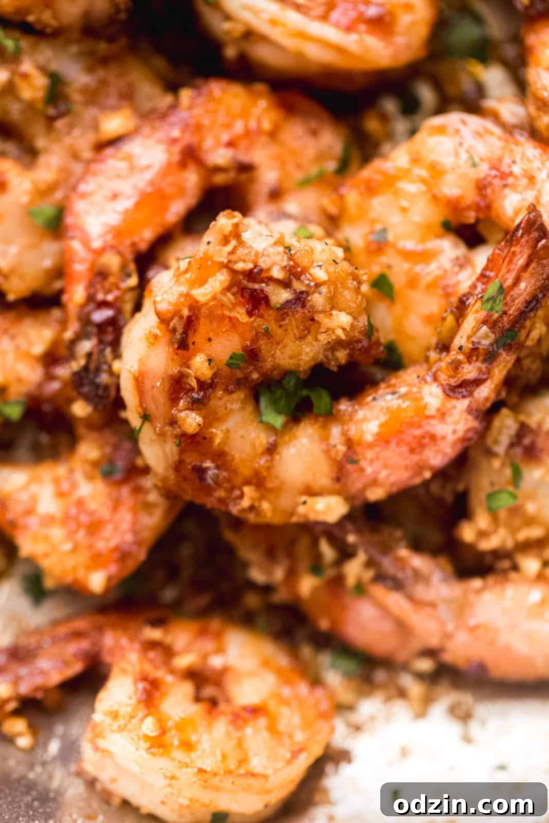 Close up of perfectly cooked shrimp coated in a sweet and savory garlic butter sauce