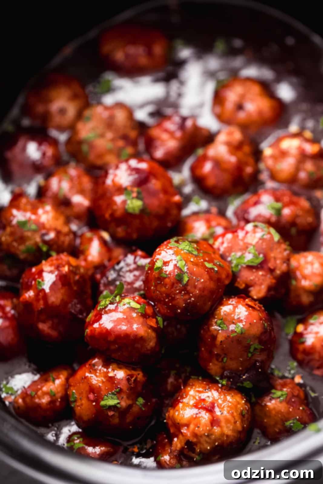 Sticky Honey Chipotle Slow Cooker Meatballs 8 slow cooker with close up of meatballs in glistening sauce with chopped parsley on top