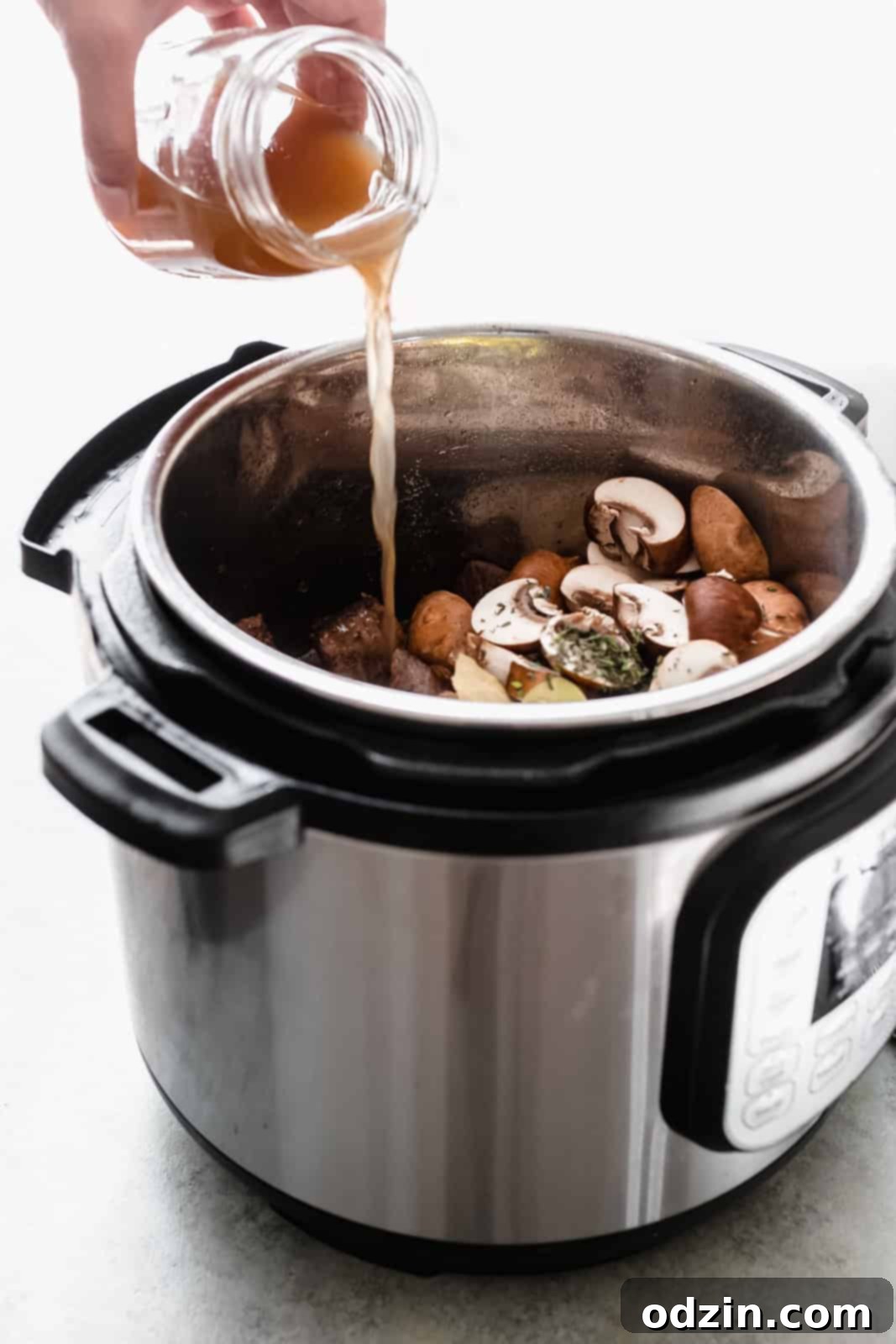 Tender Beef Tips with Savory Mushroom Gravy Slow Cooker Instant Pot 7 pouring beef stock into the instant pot before pressure cooking the stew
