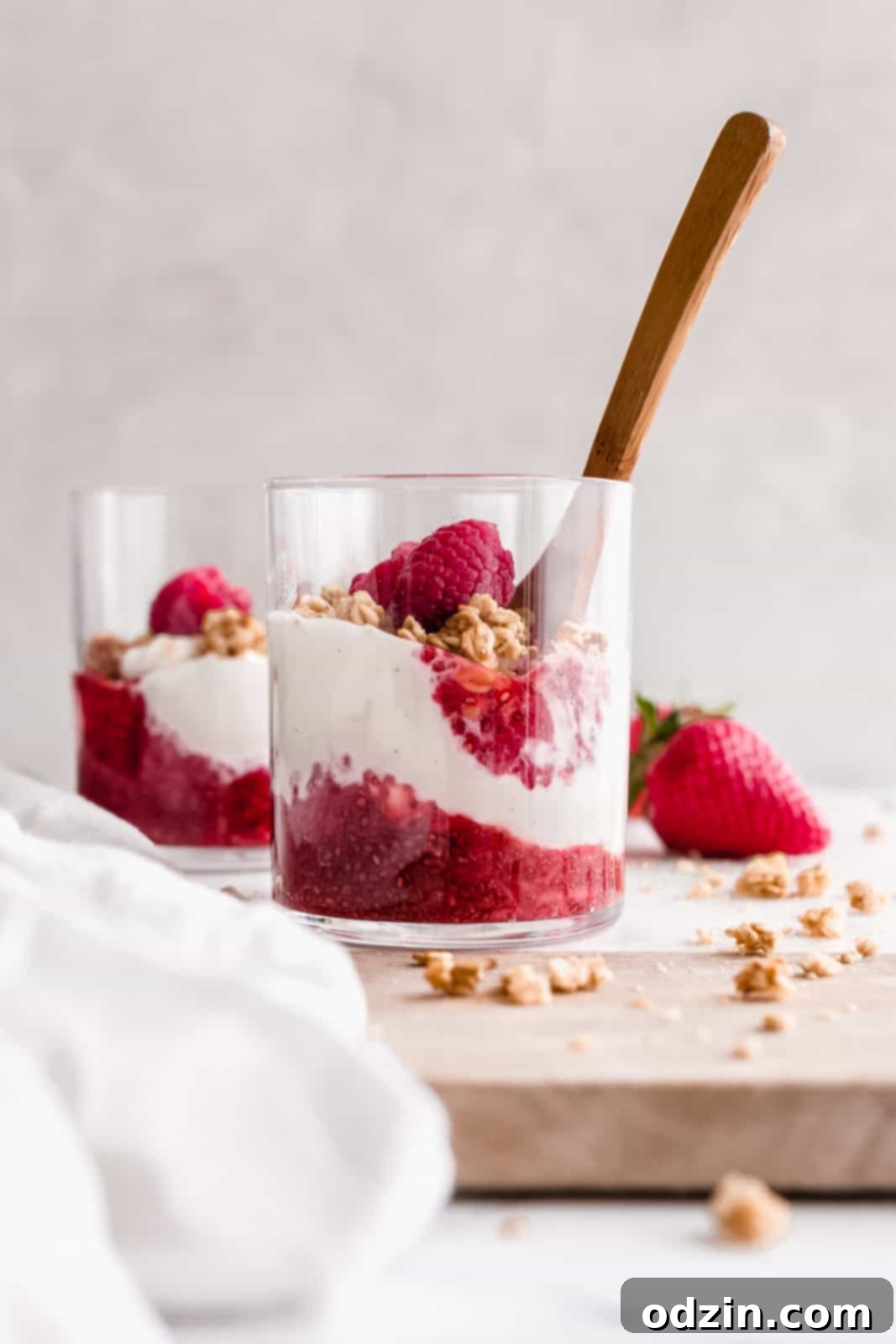 glass of yogurt parfait with chia jam, granola and fresh berries