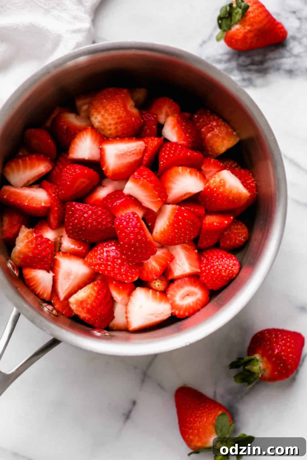 berries in saucepan before cooking on white marble