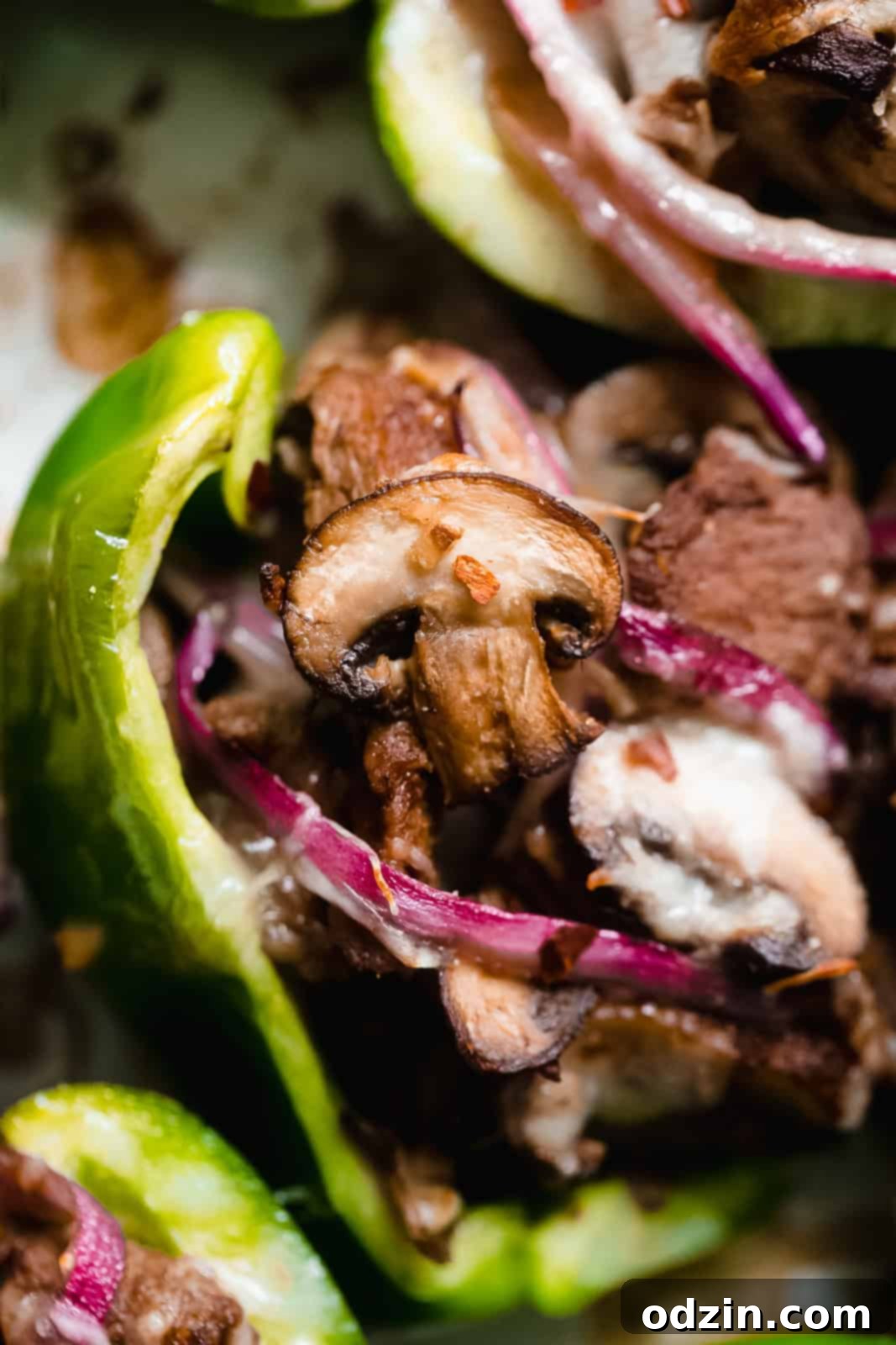 close of up softened pepper with steak, cheese, mushrooms, and onions