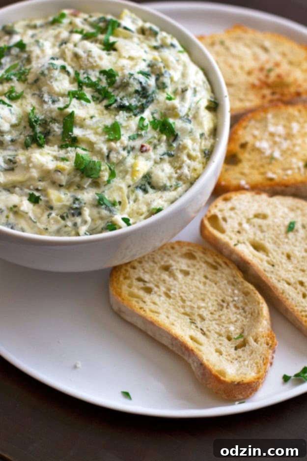 A delicious serving of homemade spicy spinach and artichoke dip, garnished and ready to be enjoyed, representing the final dish from the recipe.