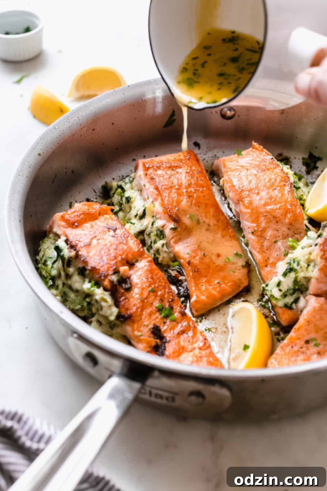 drizzling lemon butter sauce on seared salmon filets