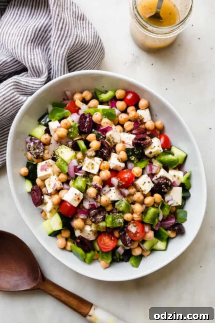 Marinated Feta Greek Salad - this is the best greek salad ever! It starts with feta that you marinated in olive oil with a few herbs and spices, then we'll toss it all together in a bowl with a homemade vinaigrette. Trust me, you'll never want a regular greeksalad again! #marinatedfeta #greeksalad #authenticgreeksalad #fetasalad #salad #saladrecipes | Littlespicejar.com dressed and prepared Greek salad topped with marinated feta cheese