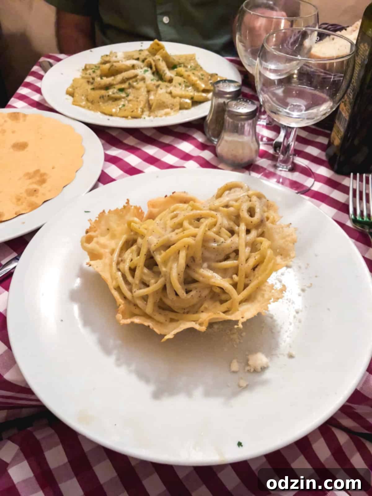 cacio e pepe in a parmesan bowl on a white plate
