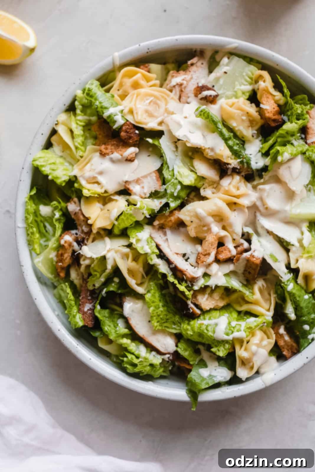 Close-up of a delicious plate of Tortellini Caesar Salad with chicken, romaine, and parmesan