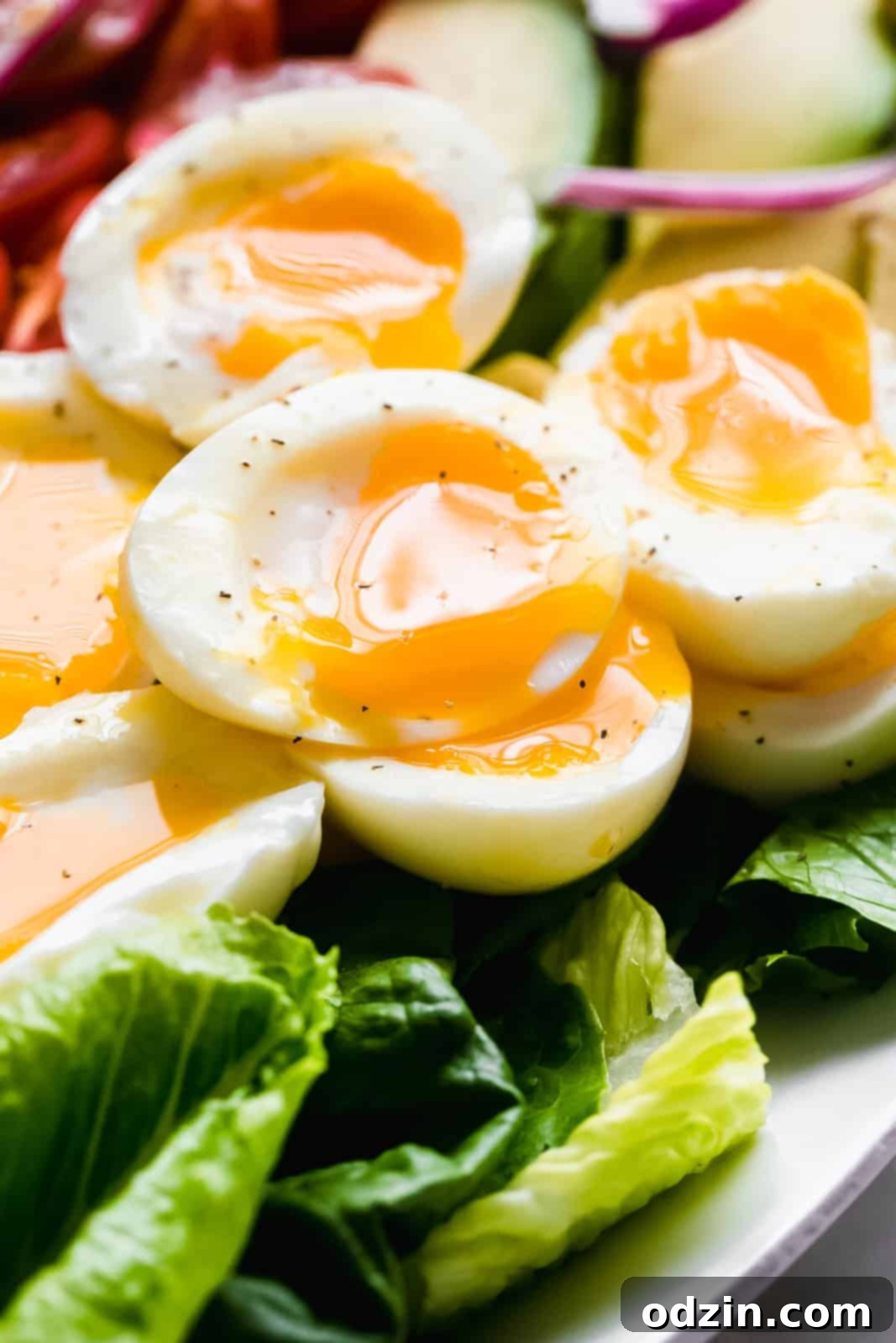 Close-up of a soft-boiled egg half with a luscious, dripping yolk, nestled on a bed of fresh lettuce.