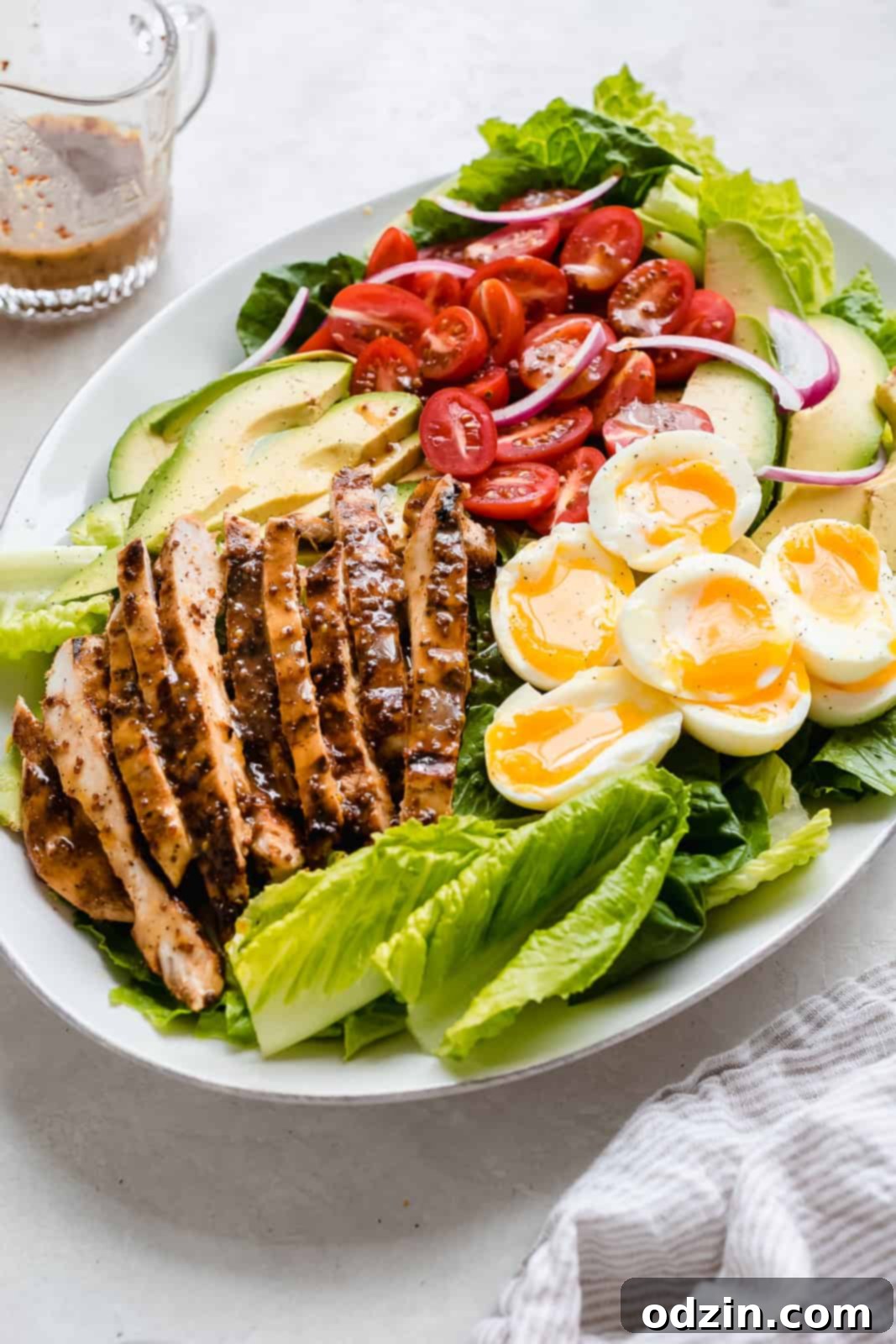 A beautifully arranged platter showcasing all the vibrant ingredients of the Honey Mustard Chicken Cobb Salad, ready to be served.