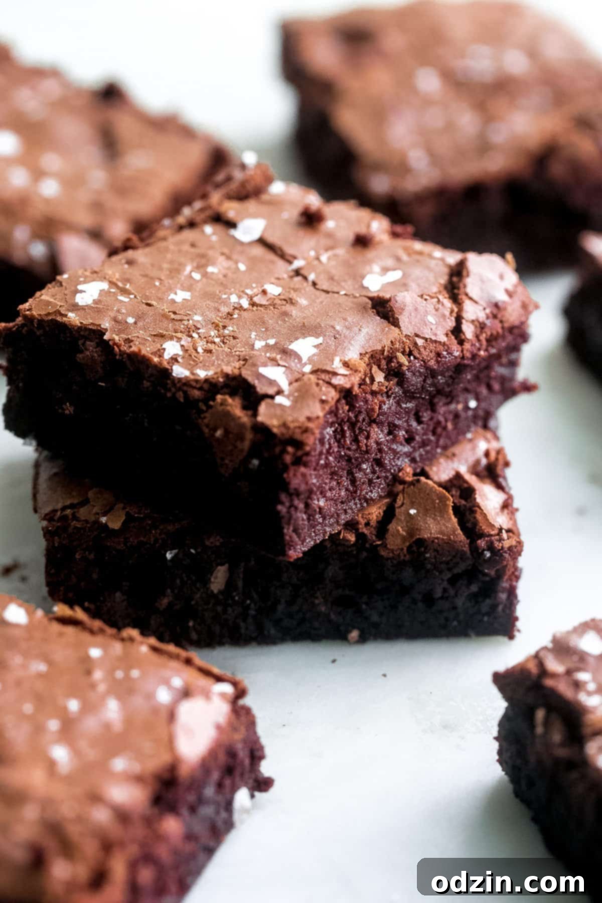 Decadent Pan-Banging Salted Fudge Brownies 8 prepared brownie pieces stacked on top of each other, surrounded by more cut brownies