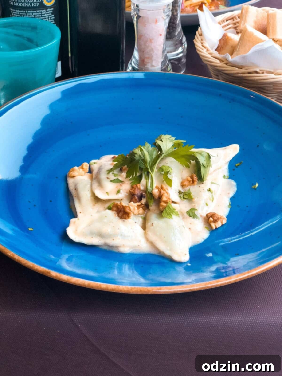 blue plate with fresh pasta, cream sauce, and walnuts