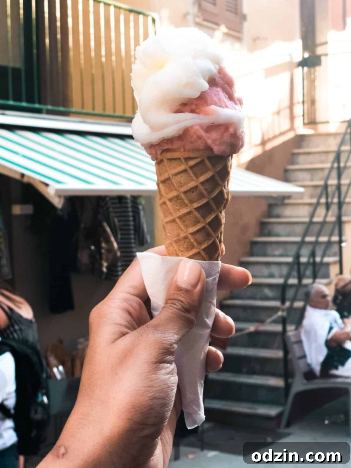 scoops of lemon and strawberry gelato on a cone