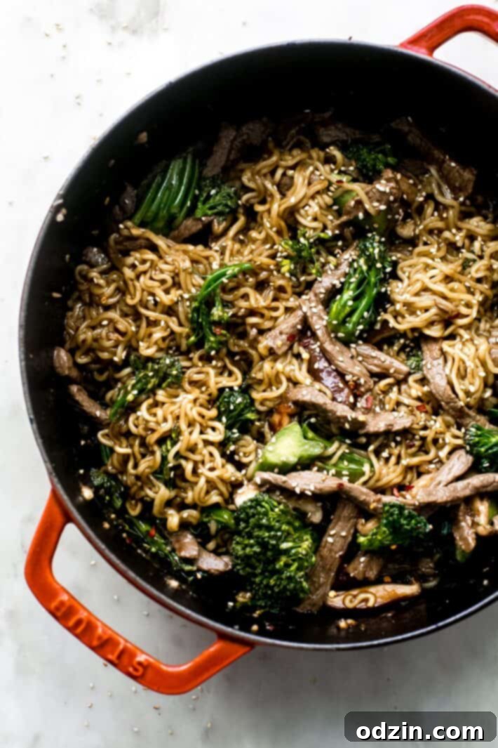 cast iron pot with ramen noodles with broccolini and sautéed beef, ready to serve