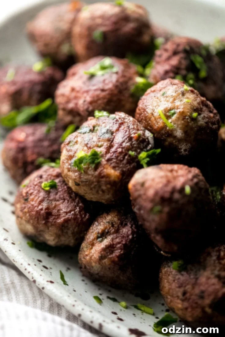 Greek Meatballs (Keftedes) on a serving platter with fresh herbs