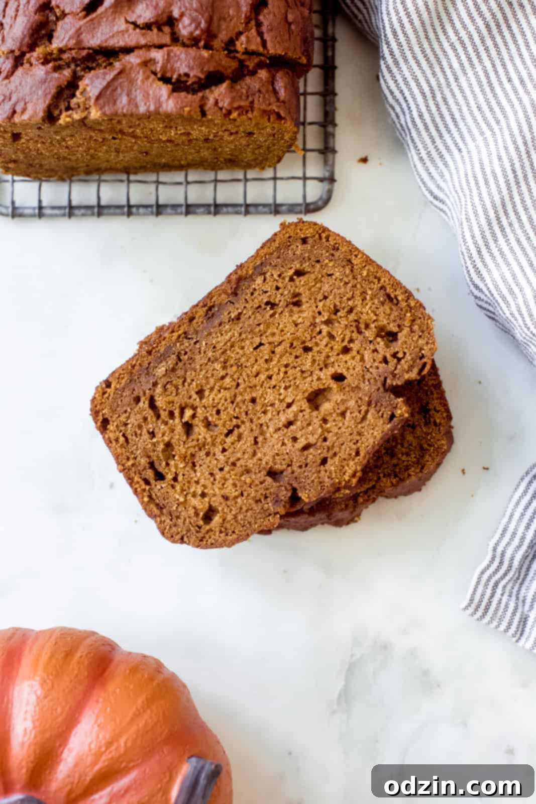 slices of perfectly baked brown butter pumpkin bread on a white ceramic plate