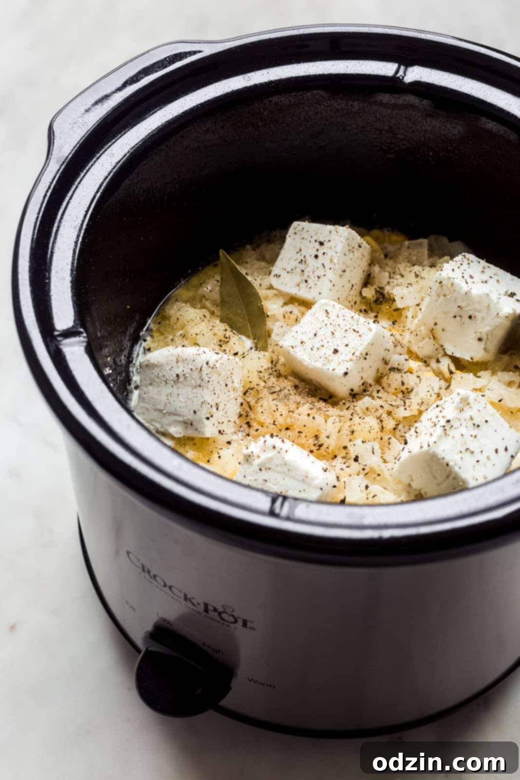 ingredients for creamed corn in a slow cooker before mixing