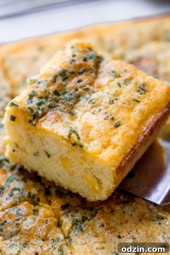Delicious Garlic Cheddar Chive Spoonbread – a quick Thanksgiving side Freshly baked garlic cheddar chive spoonbread bubbling in a cast-iron skillet, ready to be served.