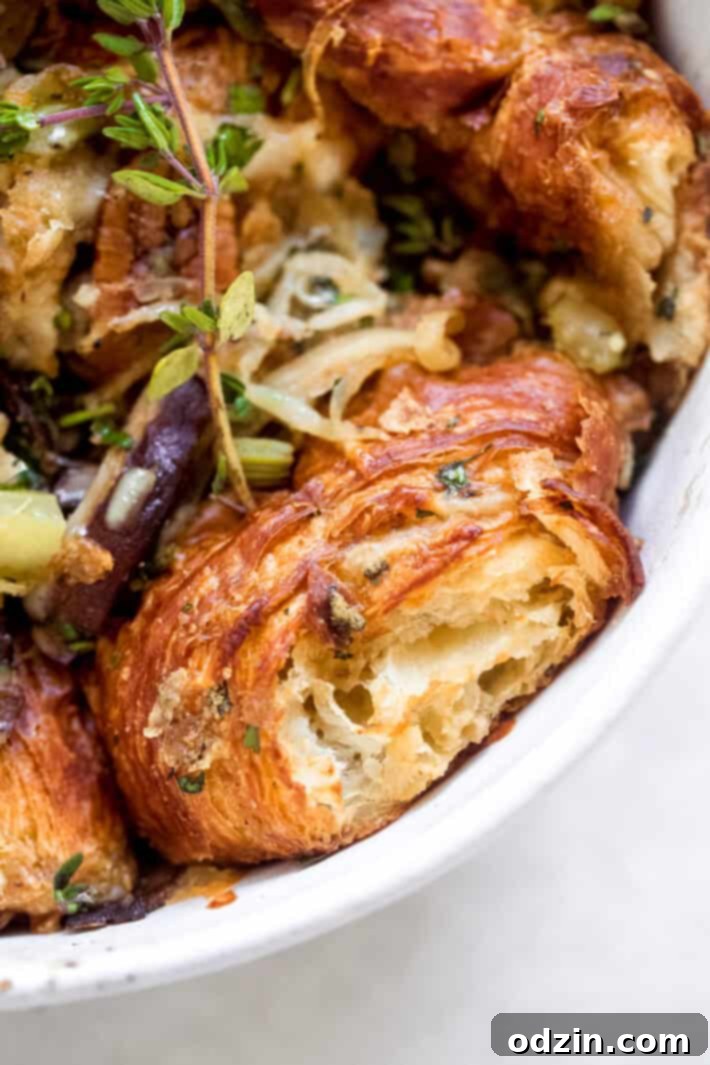 Close-up of golden brown caramelized onion croissant stuffing in a casserole dish.