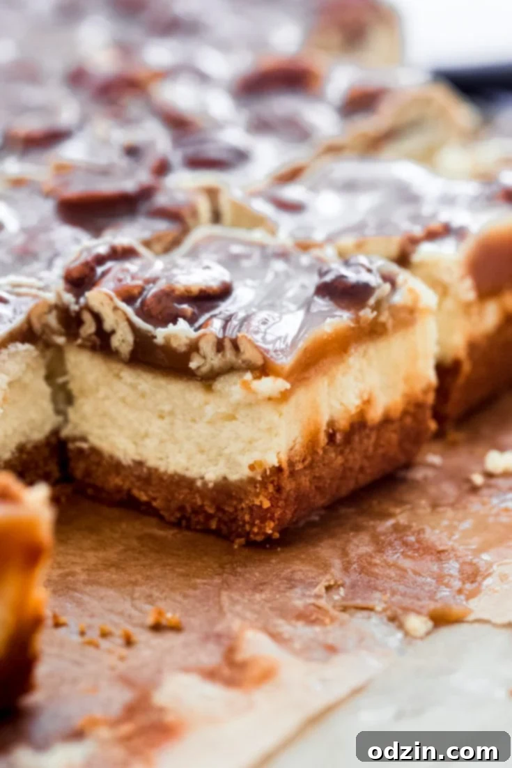 Pecan Pie Cheesecake Bars with a golden caramel topping and visible layers
