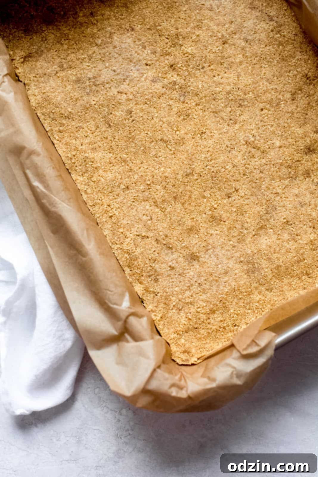 Prepared graham cracker crust, evenly pressed into a baking dish lined with parchment paper