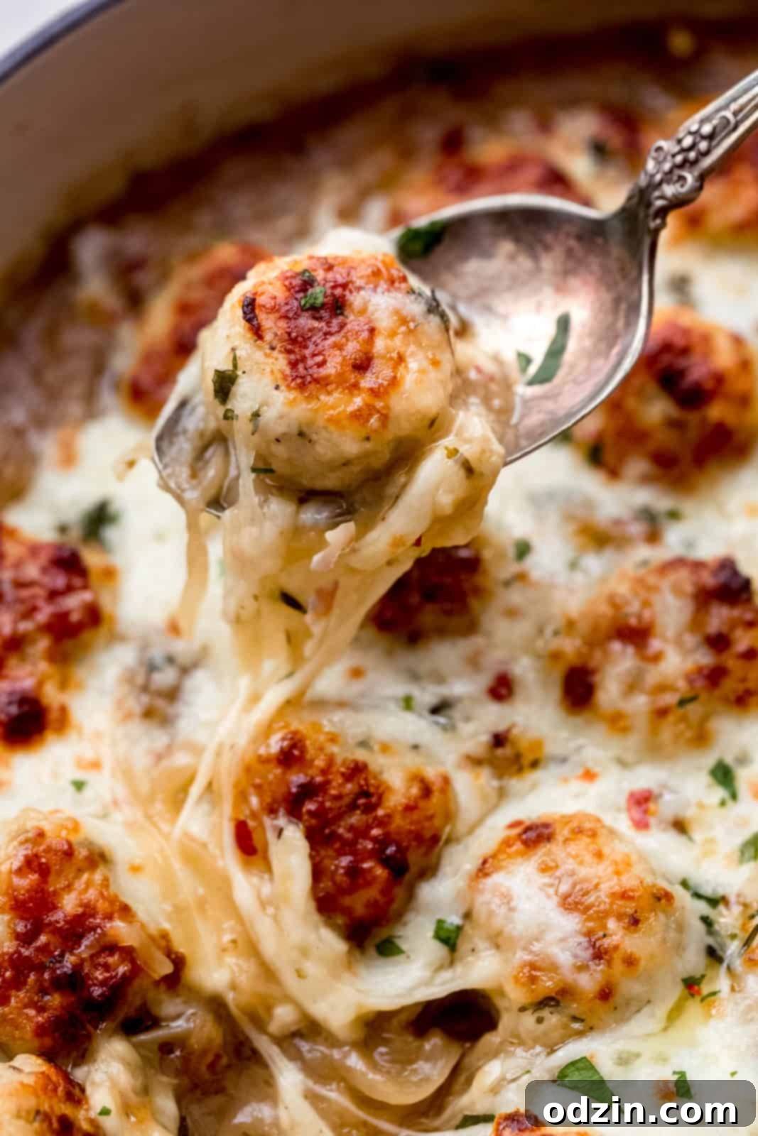 chicken meatballs with cheese on a metal spoon
