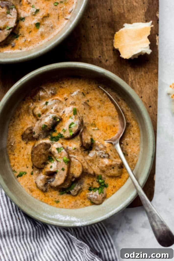 Rich & Comforting Hungarian Mushroom Soup 2 green bowl with prepared mushroom soup with a spoon