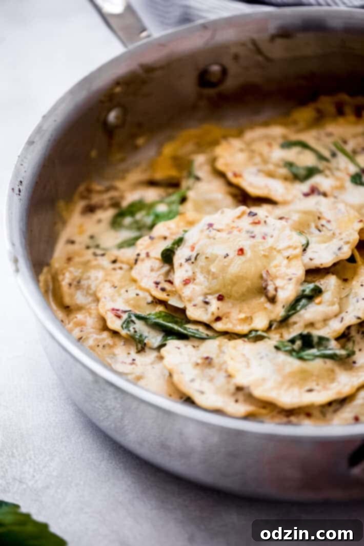 Creamy Tuscan Ravioli For An Unforgettable Date Night 2 ravioli in a skillet with wilted spinach