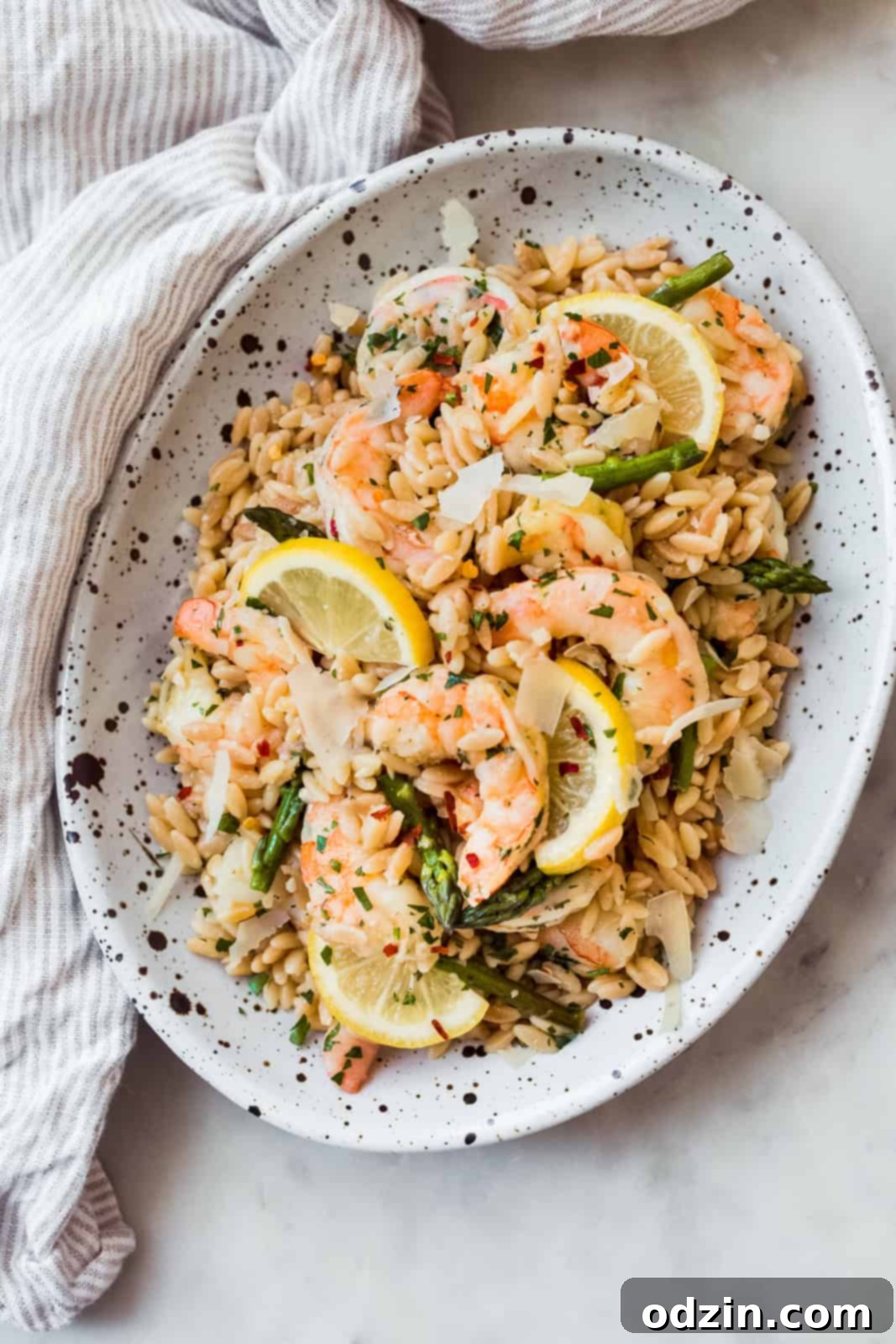 Orzo Shrimp Scampi with Asparagus oval speckled dish with prepared orzo scampi with fresh lemon slices