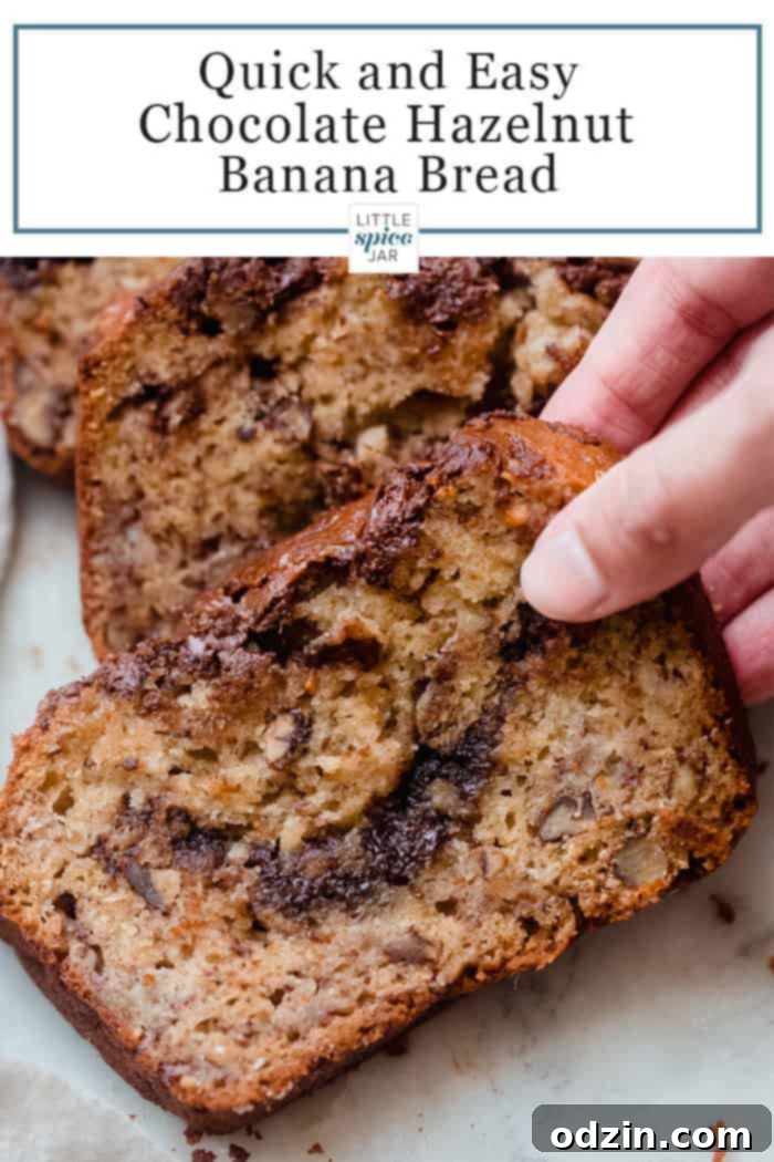 a hand holding a slice of nutella banan bread with nuts