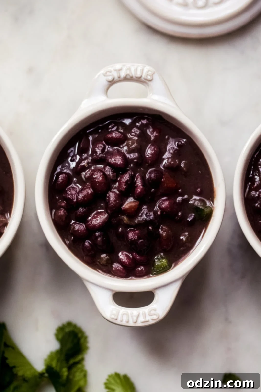 white ceramic bowl with black bean soup on marble