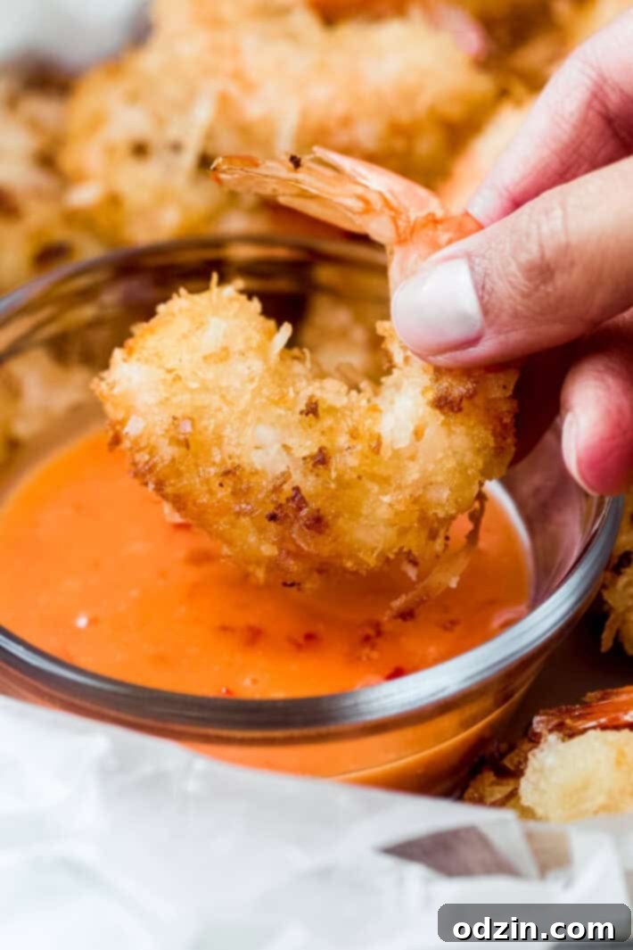 close up of golden, crispy coconut crusted shrimp from the top on a white plate