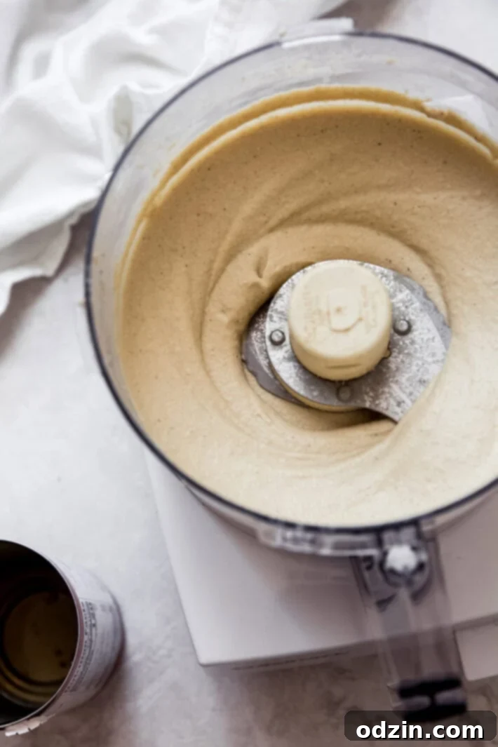 blending up tahini paste Close-up of tahini paste being blended in a food processor, highlighting its smooth and creamy texture.