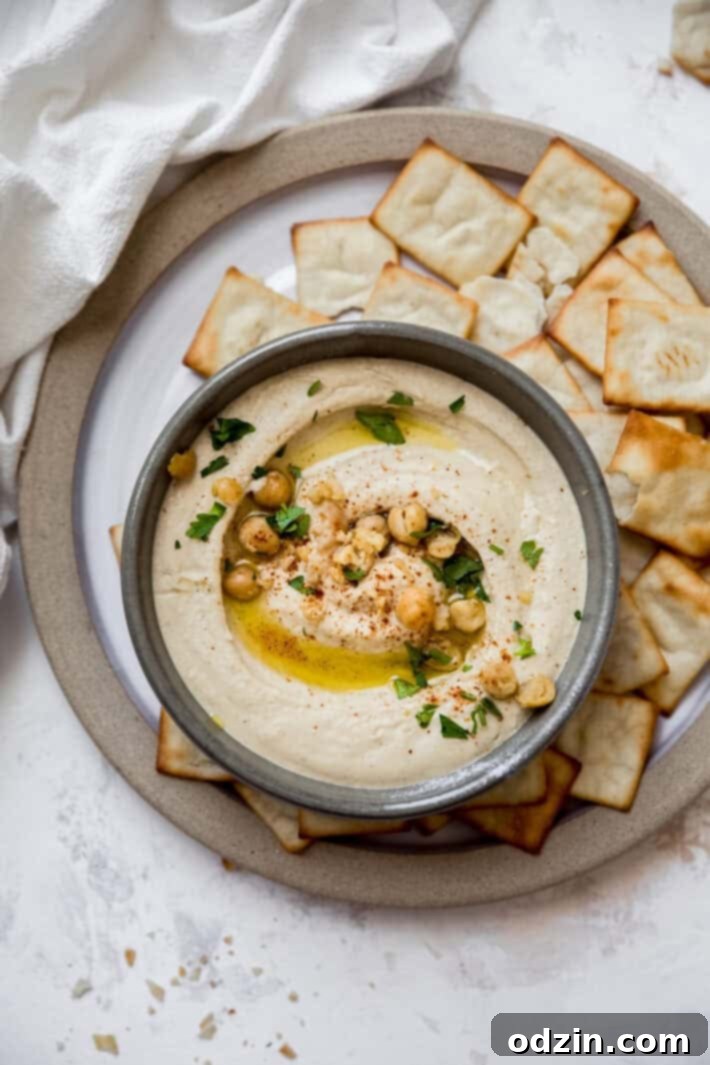 top down shot of creamy hummus A beautifully plated bowl of creamy, homemade hummus, viewed from directly above, inviting diners to scoop a bite.