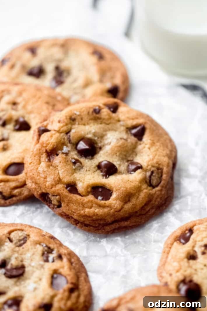 Ultimate Chewy Chocolate Chip Cookies 2 Freshly baked chocolate chip cookies cooling on wax paper, sprinkled with a touch of Maldon sea salt.