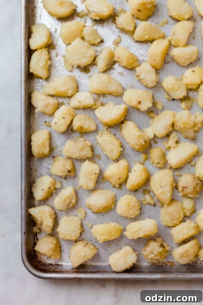 Crispy Garlic Oven Potatoes 5 parboiled potatoes spread on sheet pan ready to roast