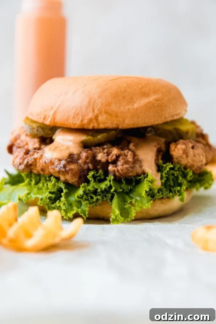 Signature Pickle Crunch Chicken Sandwich 2 Fried chicken sandwich on food paper with waffle fries