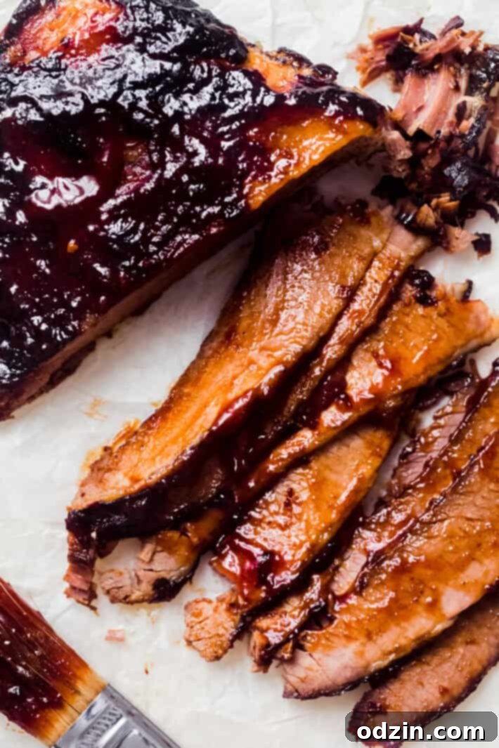 thinly sliced brisket doused in bbq sauce on white wax paper