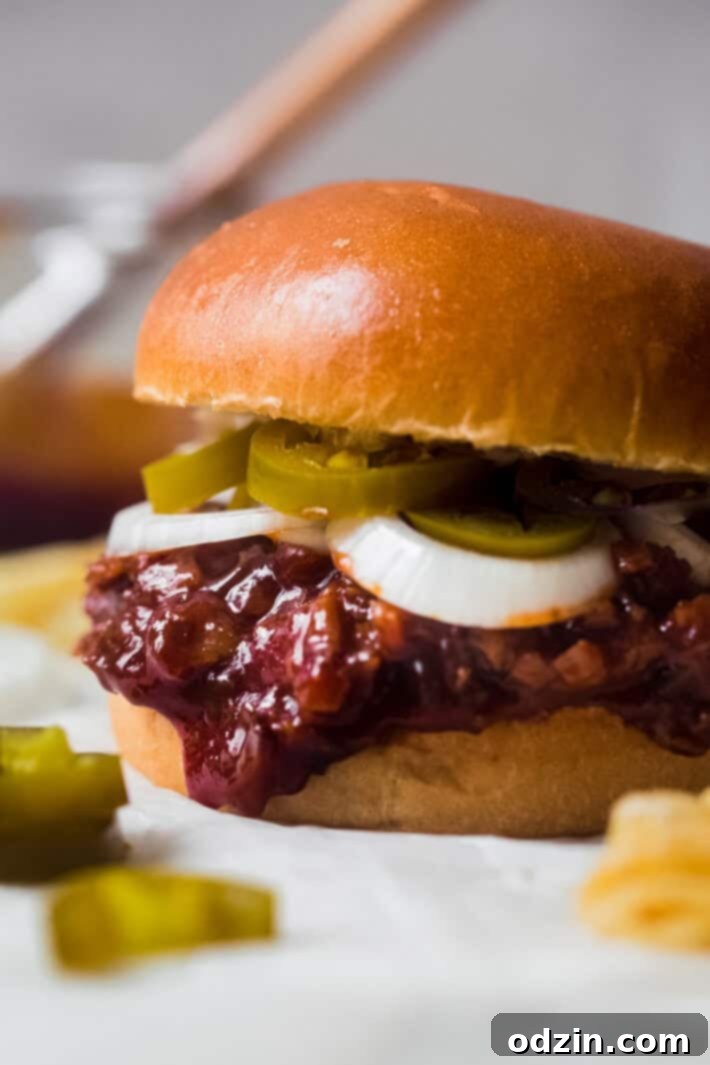 close up shot of sandwich showing the chopped beef falling out of the bun