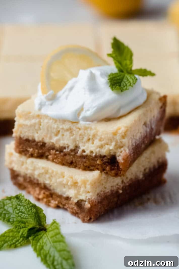 stack of two lemon squares with whipped cream, sprig of mint, and a lemon slice