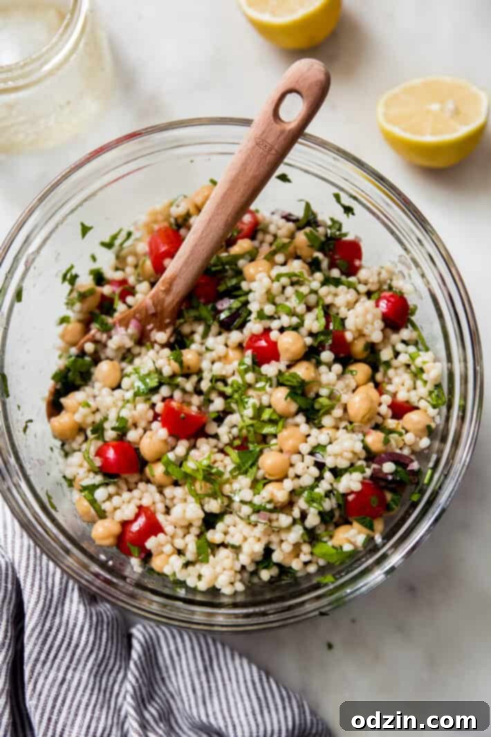 bowl with prepared salad and wooden spoon on white marble