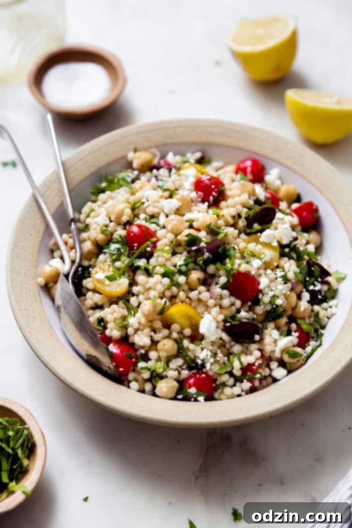 rimmed plate with prepared Israeli couscous chickpea salad
