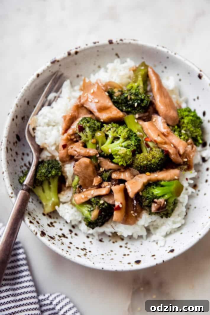 specked bowl filled with rice topped with chicken broccoli stir fry