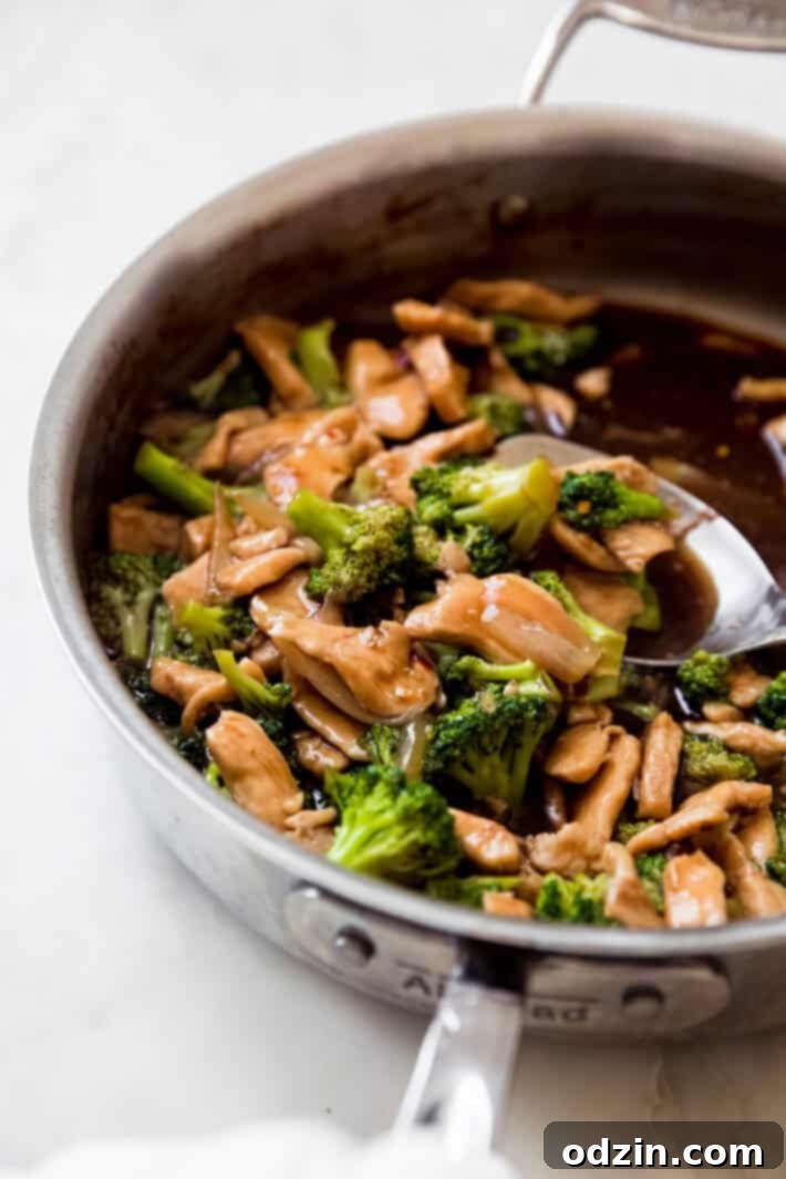 side shot of skillet with stir fry and metal serving spoon