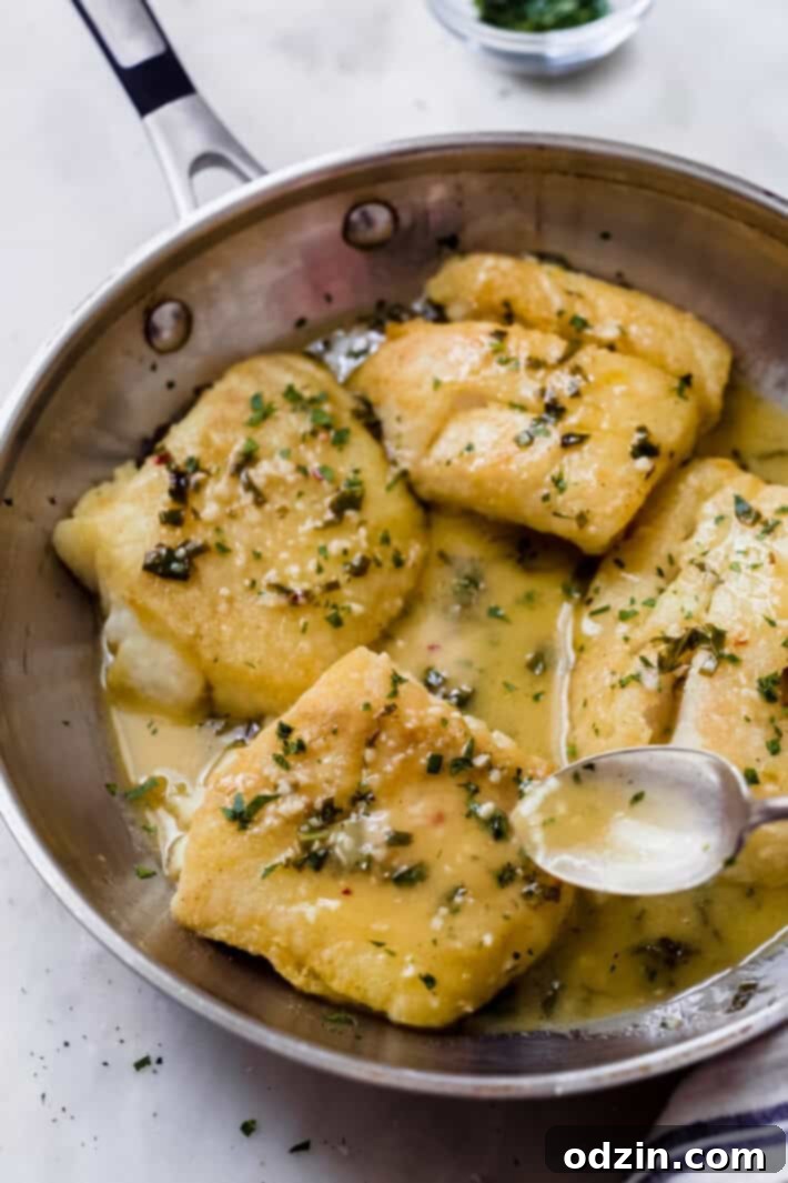 The Ultimate Pan-Fried Fish with Fresh Basil and Zesty Lemon Butter 6 spoon pouring sauce over fish filet in skillet