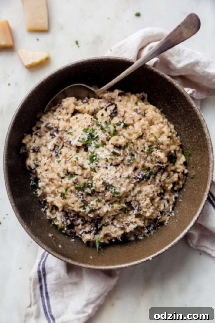 prepared risotto in ochre speckled bowl on white marble